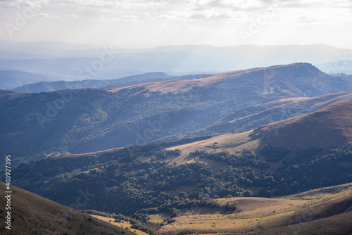 Beautiful mountain landscape of green and yellow meadows on Balkan Mountains in Serbia.Sunlit highlands and grasslands of Old mountain with distant peaks.Hiking trail for the highest peak Midzor 2169m