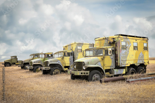 old vintage army vehicles sitting in a row for display.