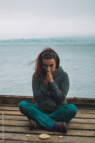 young woman meditating in front of the sea © Hector