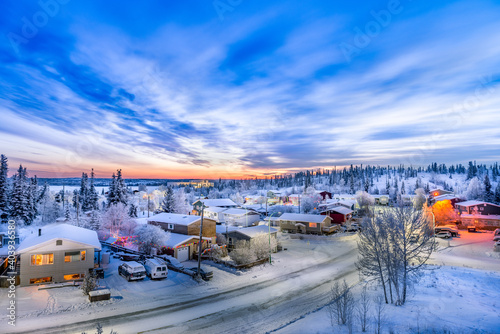 Sunrise over looking neighborhood in Yellowknife during winter with snow, road and clouds  photo