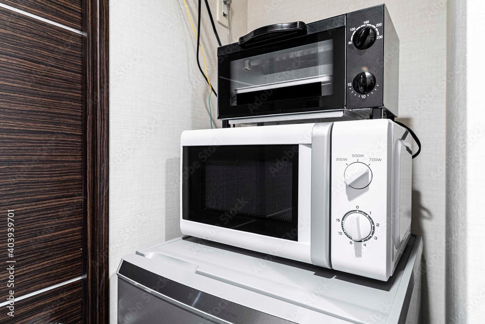 Fototapeta premium Microwave and mini oven on the fridge in the room