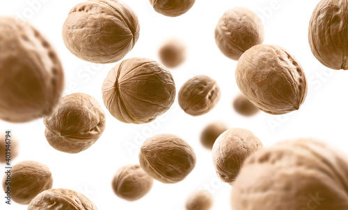 Whole walnuts levitate on a white background