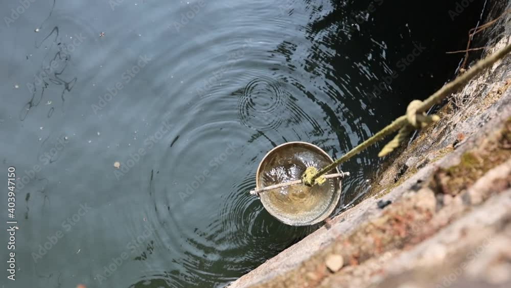 Fetching water from well by hand, fresh pure drinking mineral water
