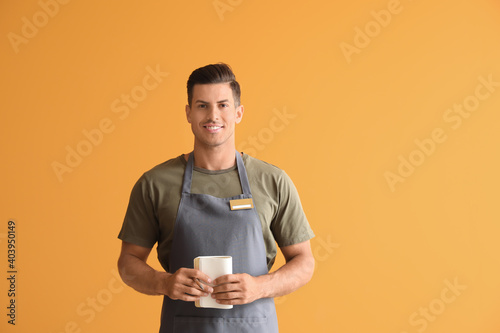 Male waiter on color backgr...
