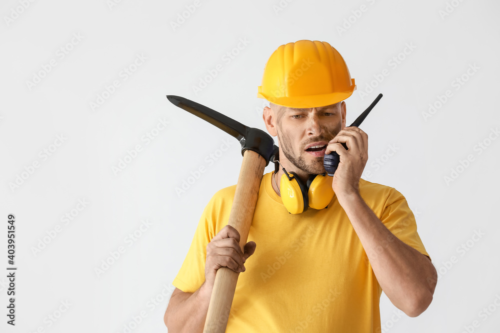 Miner man with two-way radio on light background
