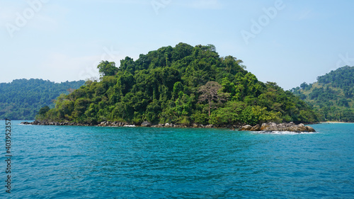 Fototapeta Naklejka Na Ścianę i Meble -  Travel by sea in Thailand by ship. View of the open ocean, green Islands and gray sky in smog. Green water with waves. Sailing between the Islands. Ship from different sides: stern, bow, rope, anchor.