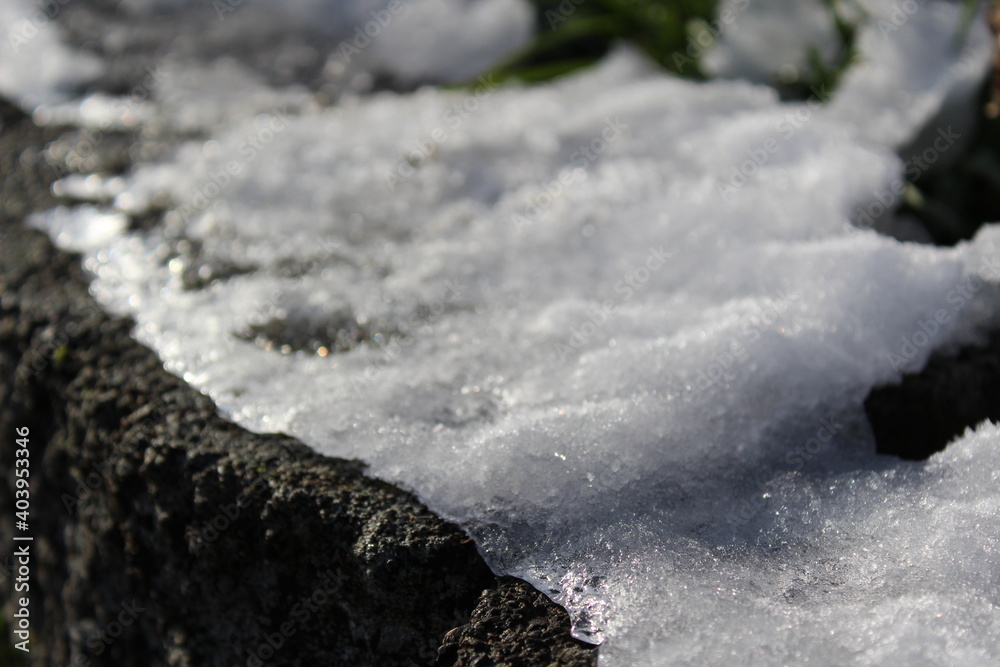 Garden rocks covered with overnight snow and melted in the morning sunlight Garden rocks covered with overnight snow and melted in the morning sunlight