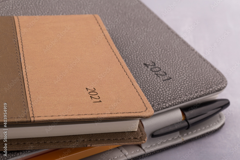 2021 schedule book and pen on gray background. 2021 schedule book and pen on gray background.