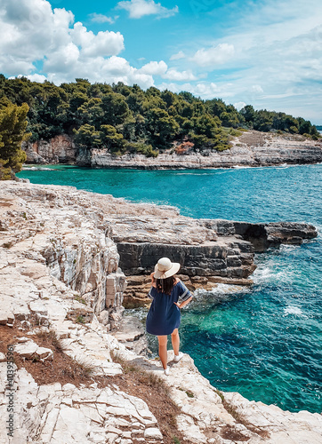 Vertical shot of a female standing on the Zavratnica Cove, Adriatic Sea, Croatia photo