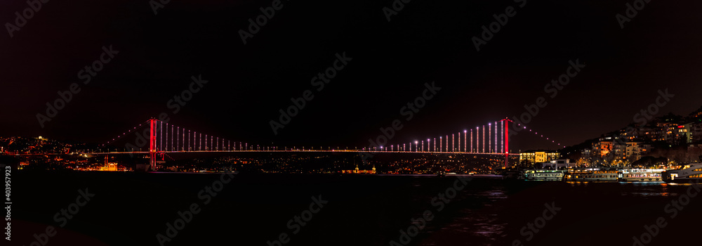A panoramic of the Bosphorus Bridge 1, officially known as the 15 July Martyrs Bridge, taken at night in January 2021 from the Asian side of Istanbul Turkey.