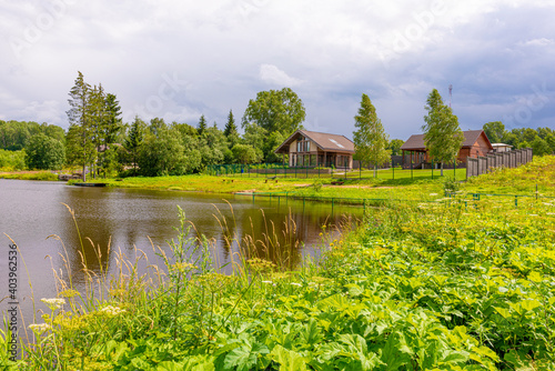modern Russian village on a flowering summer meadow on a hillock