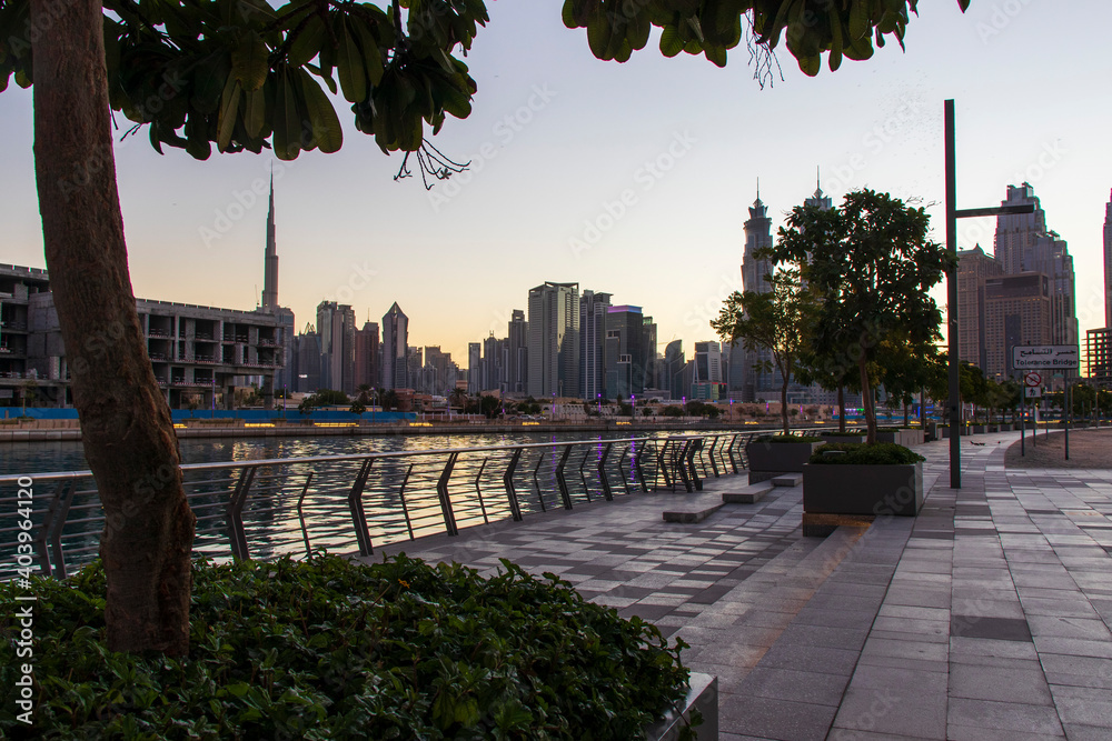 Fototapeta premium Dubai, UAE - 01.08.2021 View of the Dubai city skyline at Dubai Water Canal. Business Bay district. Tallest building in the world Burj Khalifa can be seen in the picture. Outdoors