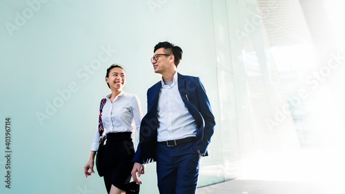 Canvas Print Asian business people in a discussion while walking