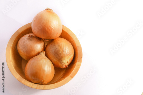 Large onion in a wooden bowl on a white background