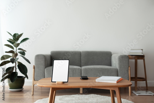 Digital tablet with blank screen on wooden table