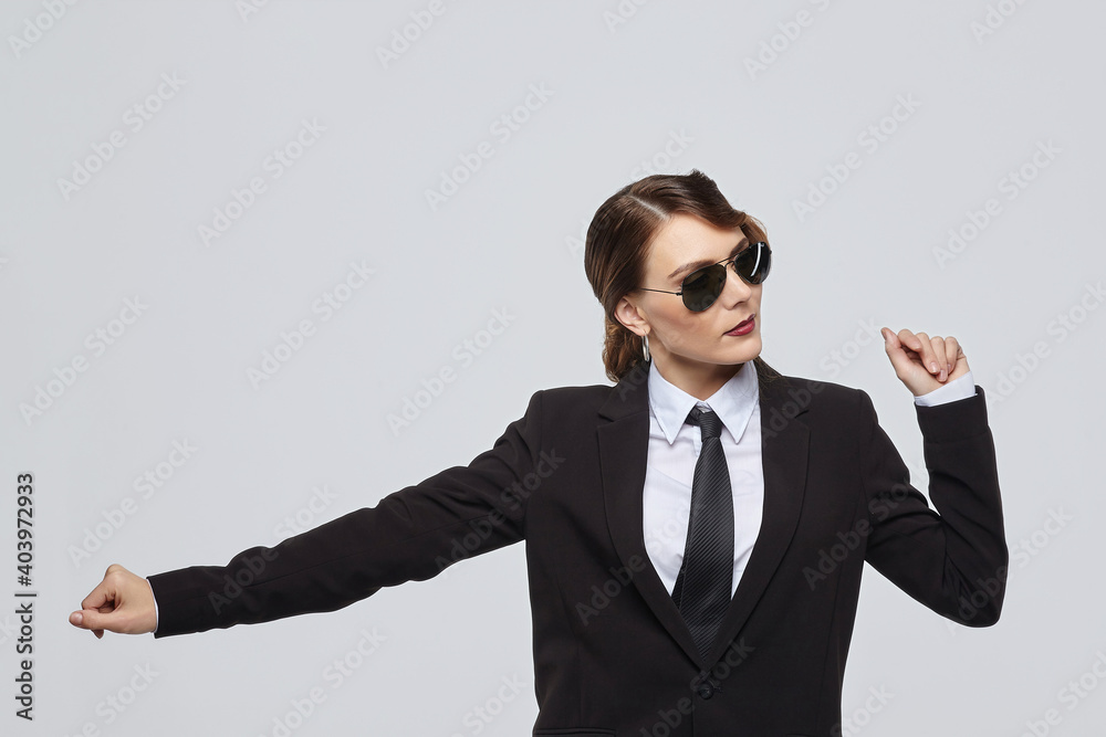 attractive woman with a retro hairstyle poses in a men's suit and sunglasses attractive woman with a retro hairstyle poses in a men's suit and sunglasses