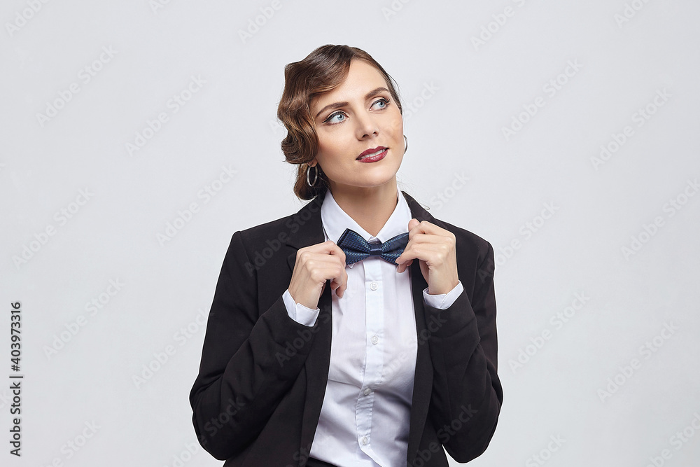 attractive woman with a retro hairstyle poses in a man's suit. photo shoot in the studio on a white background