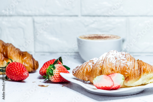 Continental breakfast with croissants. Coffee and fresh strawberries