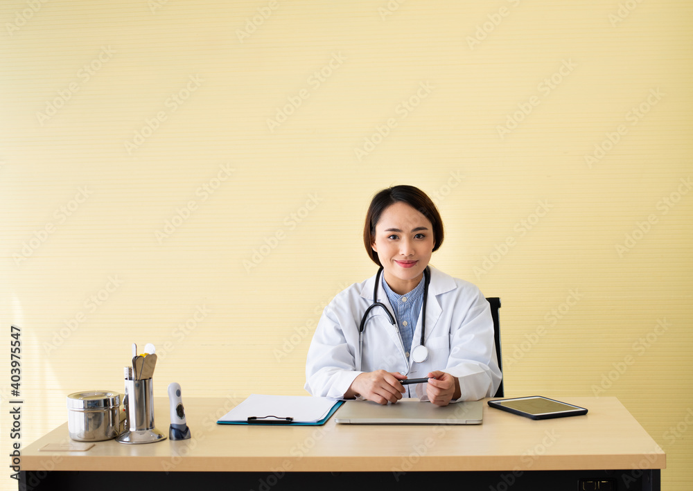 Young asian woman doctor smile while working with laptop computer at hospital, Medicine and health care concept. Young asian woman doctor smile while working with laptop computer at hospital, Medicine and health care concept.
