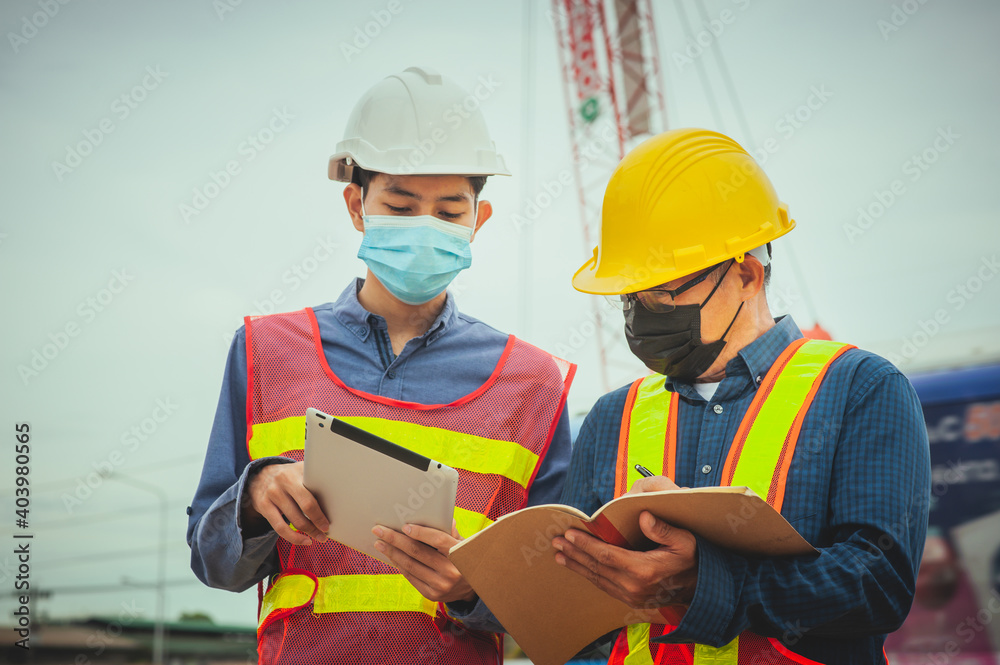 Two worker working on site construction with tablet technology and using mask prevention covid19 coronavirus Two worker working on site construction with tablet technology and using mask prevention covid19 coronavirus