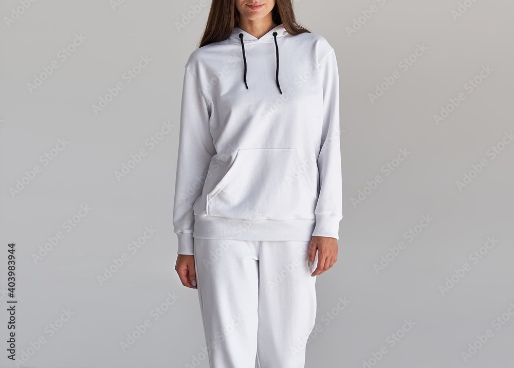 woman wears white hoodie and white pants. indoor studio shot woman wears white hoodie and white pants. indoor studio shot