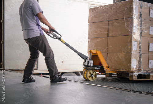 Tableau sur toile Workers Using Hand Pallet Jack Unloading Packaging Boxes into Cargo Container