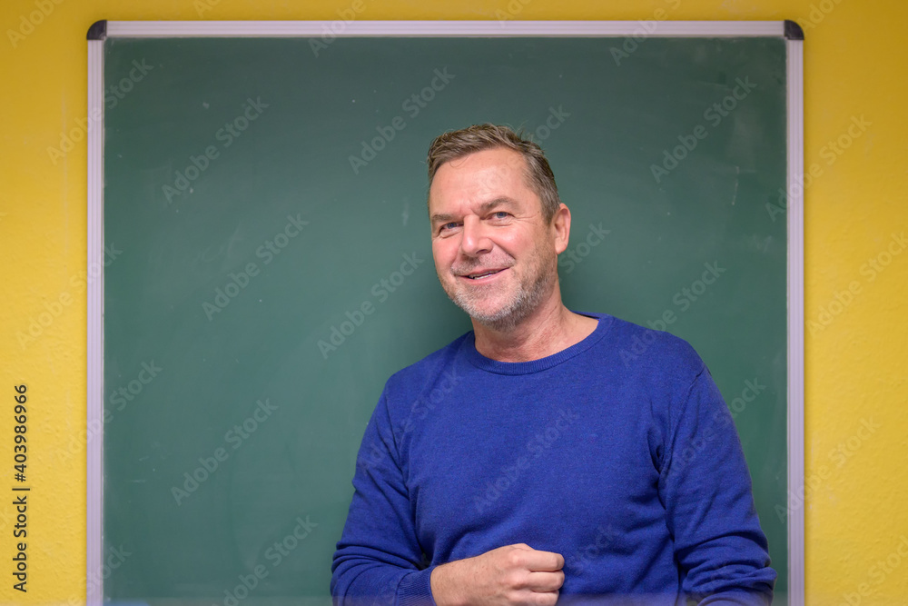 Smiling male teacher in front of a chalkboard Smiling male teacher in front of a chalkboard