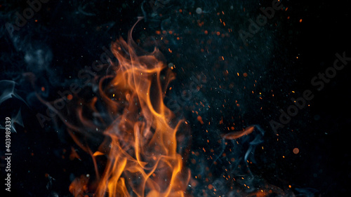 Fire flames with sparks on a black background, close-up