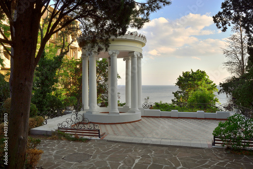 Round rotunda-gazebo with ionic columns in the garden on The black sea near Yalta