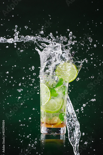 Fresh mojito drink with liquid splash and crushed ice in freeze motion, close-up