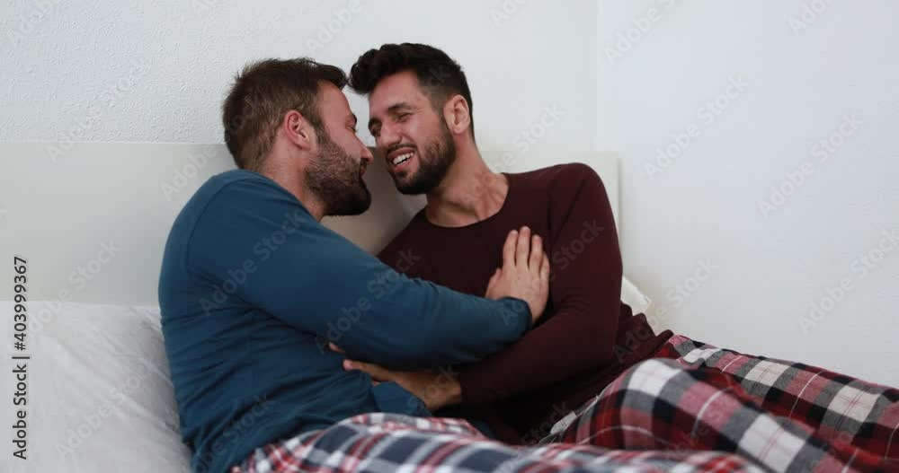 Multiracial gay men couple having tender moment in the morning in bedroom and hugging each other while wearing pyjama - Homosexual love and lifestyle concept Multiracial gay men couple having tender moment in the morning in bedroom and hugging each other while wearing pyjama - Homosexual love and lifestyle concept