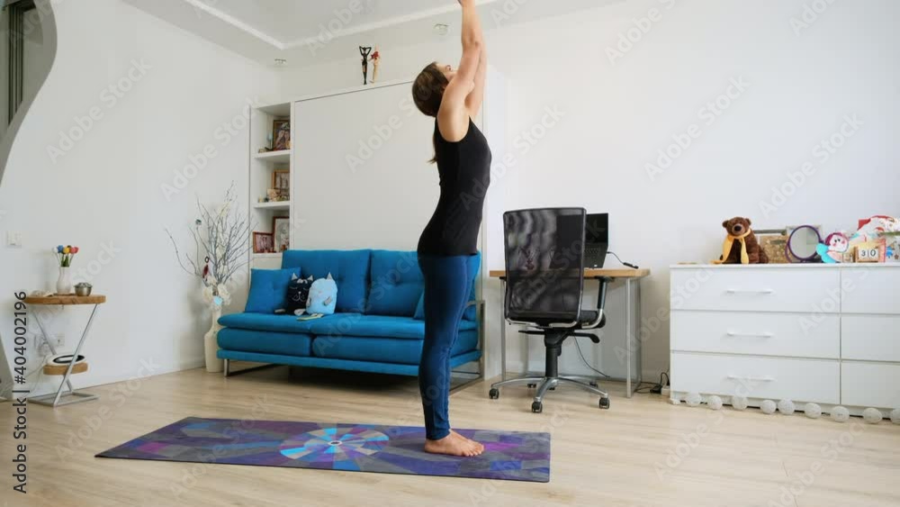 Young woman practicing yoga at home warming up Young woman practicing yoga at home warming up