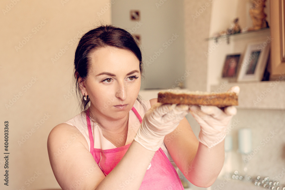 Housewife pastry chef checks the cake of the future cake for correctness. Housewife pastry chef checks the cake of the future cake for correctness.