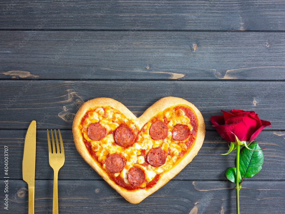 Heart shaped pizza with rose, copy space. Pepperoni pizza. Valentine dinner. Heart shaped pizza with rose, copy space. Pepperoni pizza. Valentine dinner.