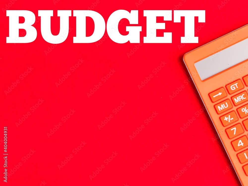 Fotografie Text BUDGET on red background with orange calculator