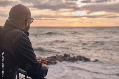 Un giovane ragazzo sta ammirando il meraviglioso tramonto sul mare da Riomaggiore  photo