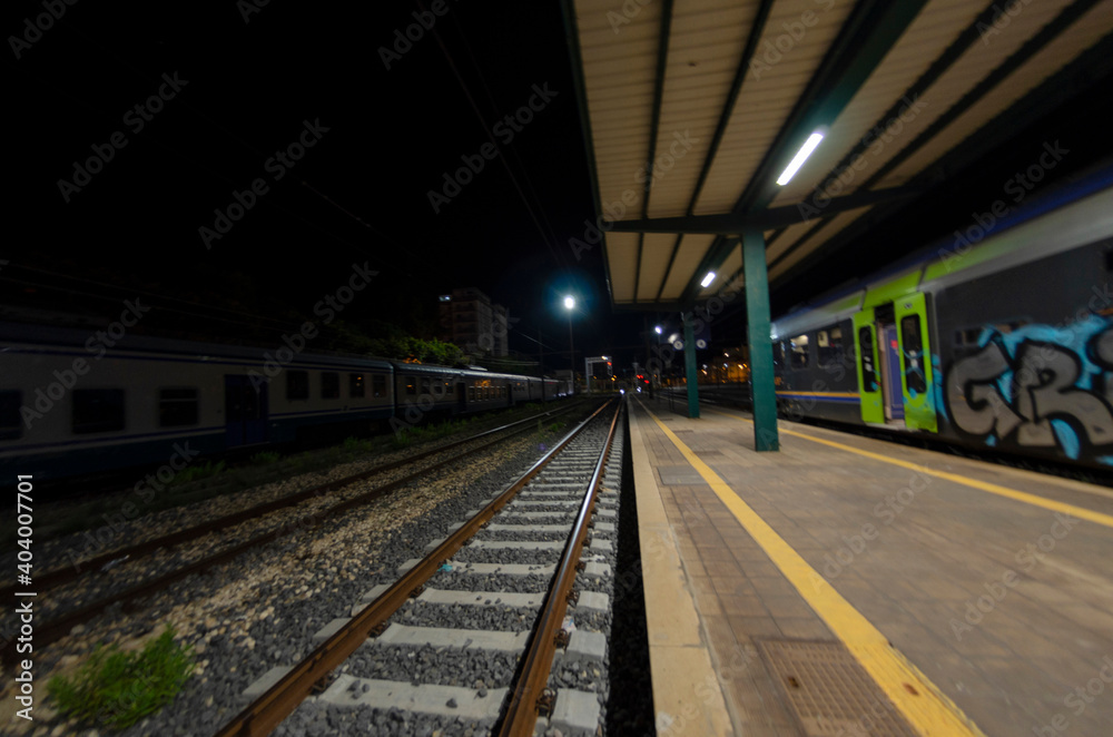 Railway station with train waiting on the tracks at night