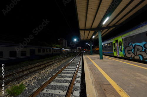 Railway station with train waiting on the tracks at night