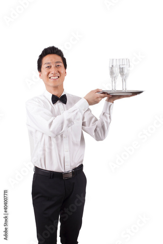 Young waiter carrying wine bottle and glasses 