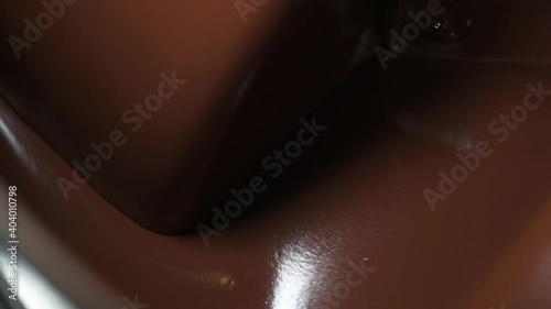Liquid melted chocolate inside a chocolate conching machine. The machine grind the chocolate to smooth paste with friction and heat.