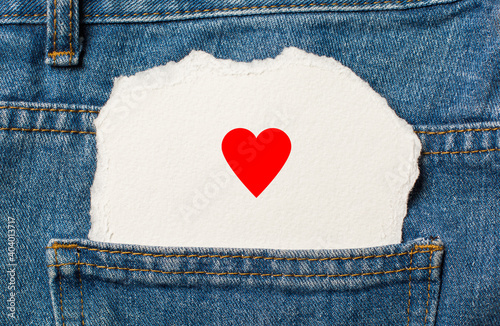 heart on torn paper background on jeans love and valentine concept