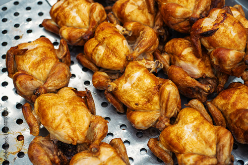 Grilled chicken. A lot of broiler carcasses baked with a yellow crust are on the counter in the store. Trade in finished products for fast food. Close-up