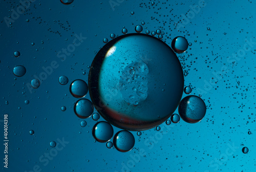 Large drops of oil in water on a blue background taken on a blue background