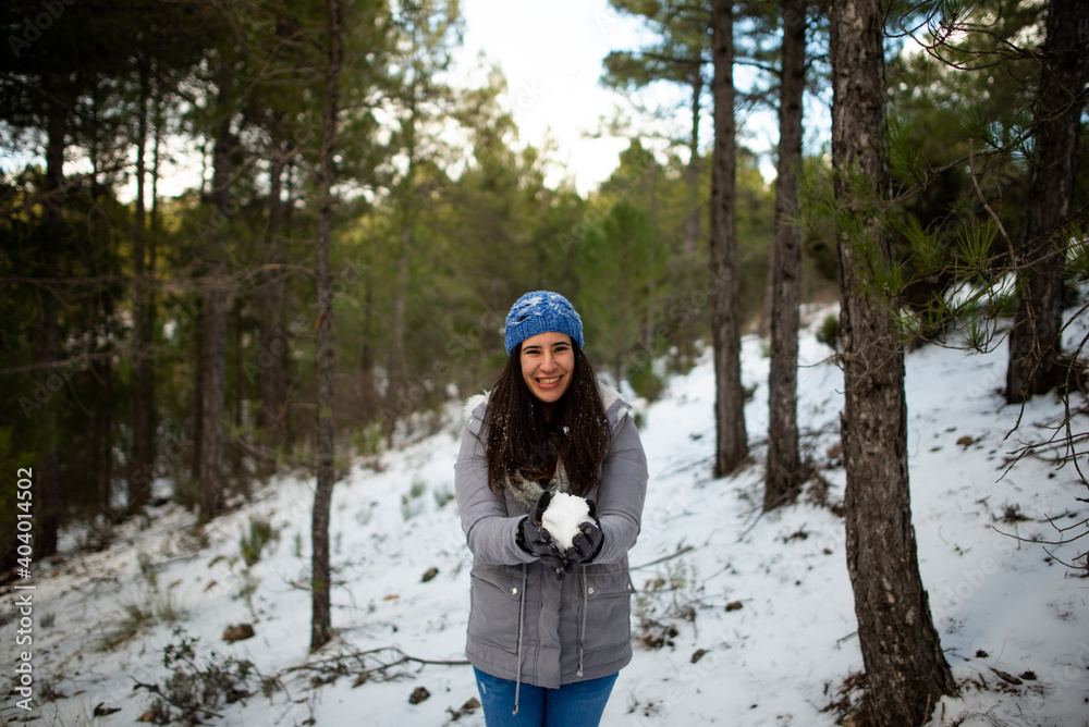 pretty brunette woman enjoying the snow on the snowy mountain with blue hat and winter coat pretty brunette woman enjoying the snow on the snowy mountain with blue hat and winter coat
