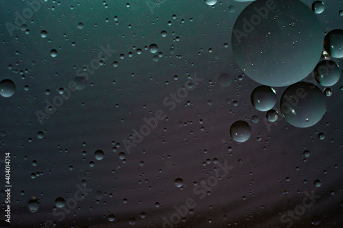 Oil drops in water taken close up on a dark background