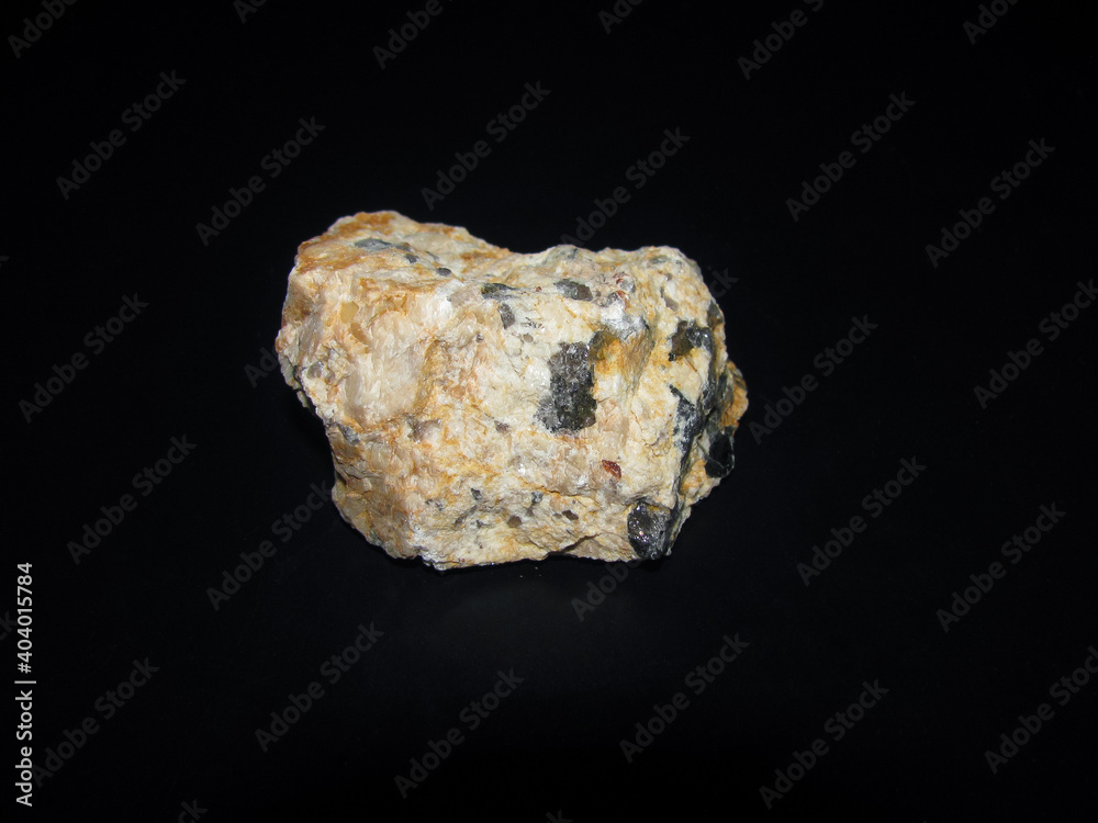 Streaks of pegmatite in the mineral. Beige stone with gray streaks. Streaks of pegmatite in the mineral. Beige stone with gray streaks.