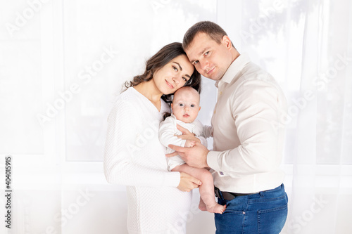 happy family mother and father hold a newborn baby at home, the concept of happy loving family, lifestyle