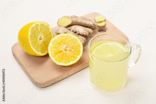 Cup of lemon ginger lemonade and ingredients on cutting board