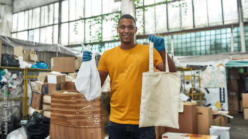 Man holding reusable cotton bag and plastic packet photo