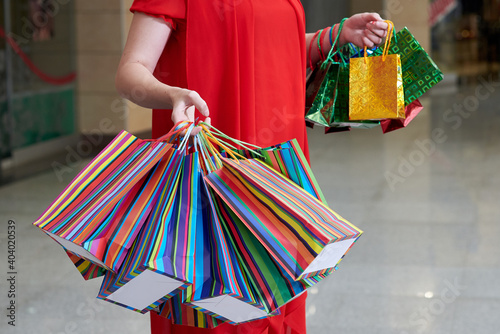Girl's hands with multicolored paper shopping bags